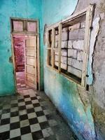 Room with checkered floor and worn down colorful walls photo