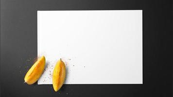 Rodajas de mango con especias sobre papel blanco sobre fondo negro foto