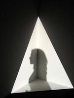 Shadow of a person in triangle of light photo