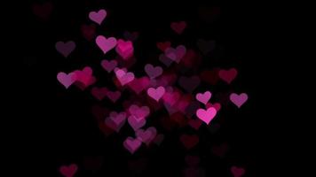 Pink and red hearts over black background video