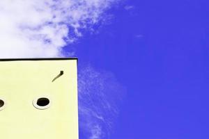 Corner of building against cloudy blue sky photo