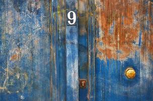Painted and rusted metal blue door with number 9