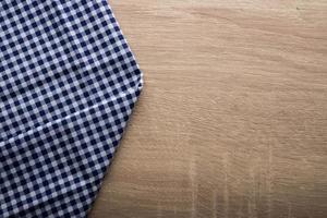 Checkered blue napkin on a wooden background photo