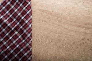 Checkered red napkin on wooden background photo