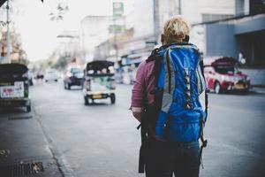Young hipster traveling backpacker around Asia photo