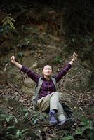 Mujer caminante en el bosque tomando un descanso foto