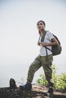 Mujer viajera con mochila en el hermoso paisaje de verano foto