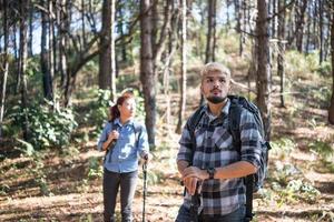 Portrait of hiking couple backpacking in a pine forest photo