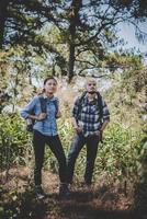 Couple hiking through forest to the mountaintop photo