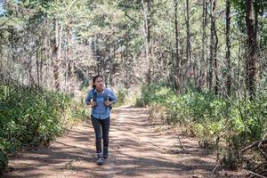 turista con mochila caminando por el bosque foto