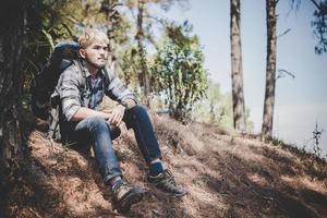 Young man traveling with a backpack in nature photo