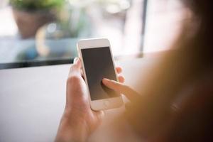 Close-up of woman's hands holding cell phone with blank copy space screen photo