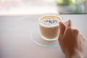 Mano de mujer con una taza de café en un café foto