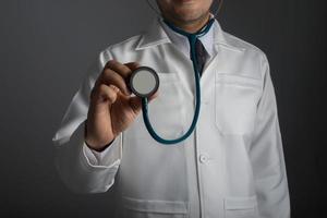 Medical doctor with a stethoscope isolated on gray background photo