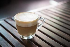 Close-up de taza de capuchino con patrón de leche en forma de corazón foto