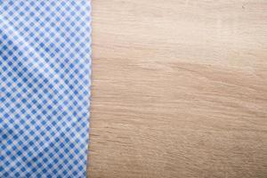 Checkered blue napkin on a wooden background photo