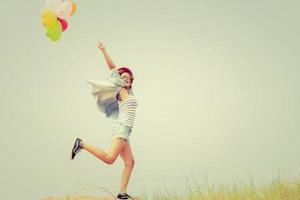 Young beautiful woman holding balloons in the fresh air photo