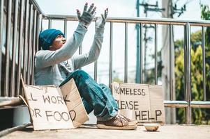 Man sitting begging on an overpass photo