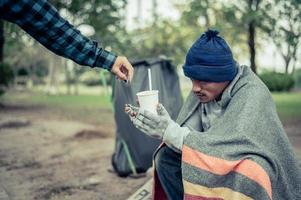 Beggar wrapped in cloth in the street accepting money photo