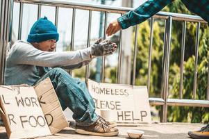 Man sitting begging on an overpass photo