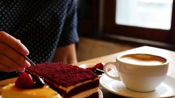 Señora comiendo pastel y café en la cafetería. video