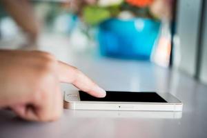 Primer plano de las manos de la mujer mediante teléfono celular con pantalla de espacio de copia en blanco foto