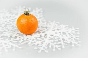 fruta mandarina hecha en un adorno con copos de nieve de papel