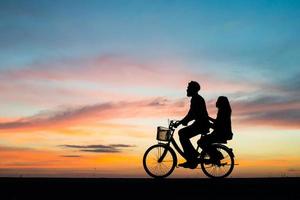 silueta, de, pareja joven, juntos, durante, ocaso foto