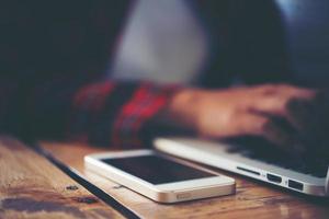 Close-up of young hipster woman using a laptop during a coffee break photo