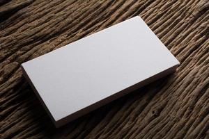 Blank white business card on wood background photo