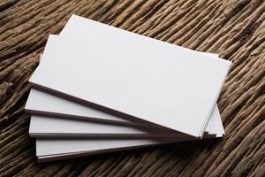 Blank white business card on wood background photo