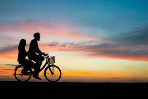 silueta, de, pareja joven, juntos, durante, ocaso foto