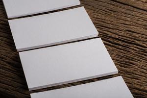 Blank white business card on wood background photo