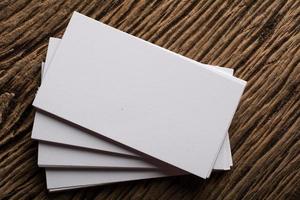 Blank white business card on wood background photo