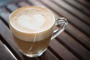 Close-up de taza de capuchino con patrón de leche en forma de corazón foto