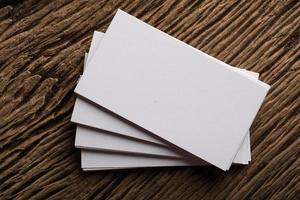 Blank white business card on wood background photo