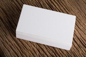 Blank white business card on wood background photo