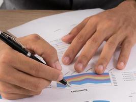 Hands of a businessman working with data charts photo