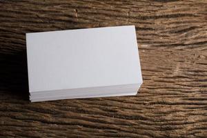Blank white business card on wood background