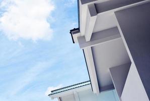 Low angle photo of white building against cloudy blue sky