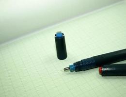 bolígrafo azul sobre papel cuadriculado