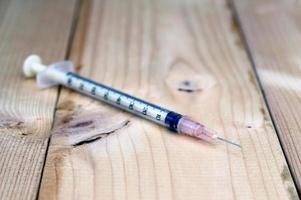 Syringe on wood photo