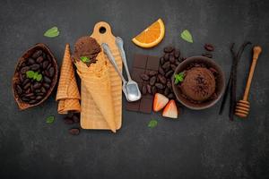 sabores de helado de chocolate en un tazón con chocolate negro y semillas de cacao foto