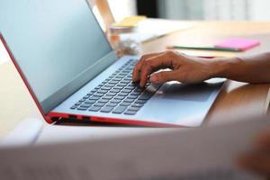 Person typing on laptop in office photo