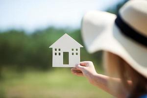 Person holding house cutout photo