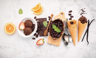 sabores de helado de chocolate en un tazón con chocolate negro y semillas de cacao foto