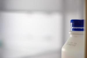 Milk bottle in refrigerator photo