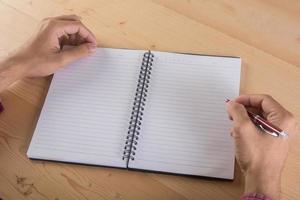 Close-up of businessman hand writing with notebook photo