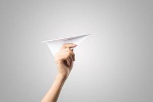 Woman's hand holding a paper airplane isolated on white background photo