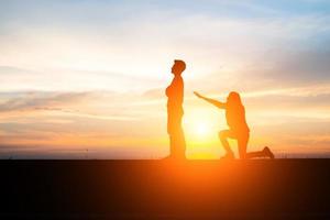 Silhouette of an upset couple in a quarrel at sunset photo